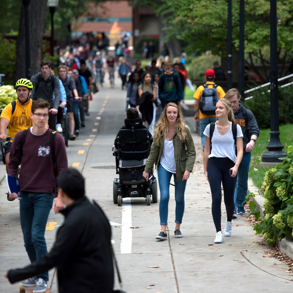 Students walk, bike, and skateboard on campus