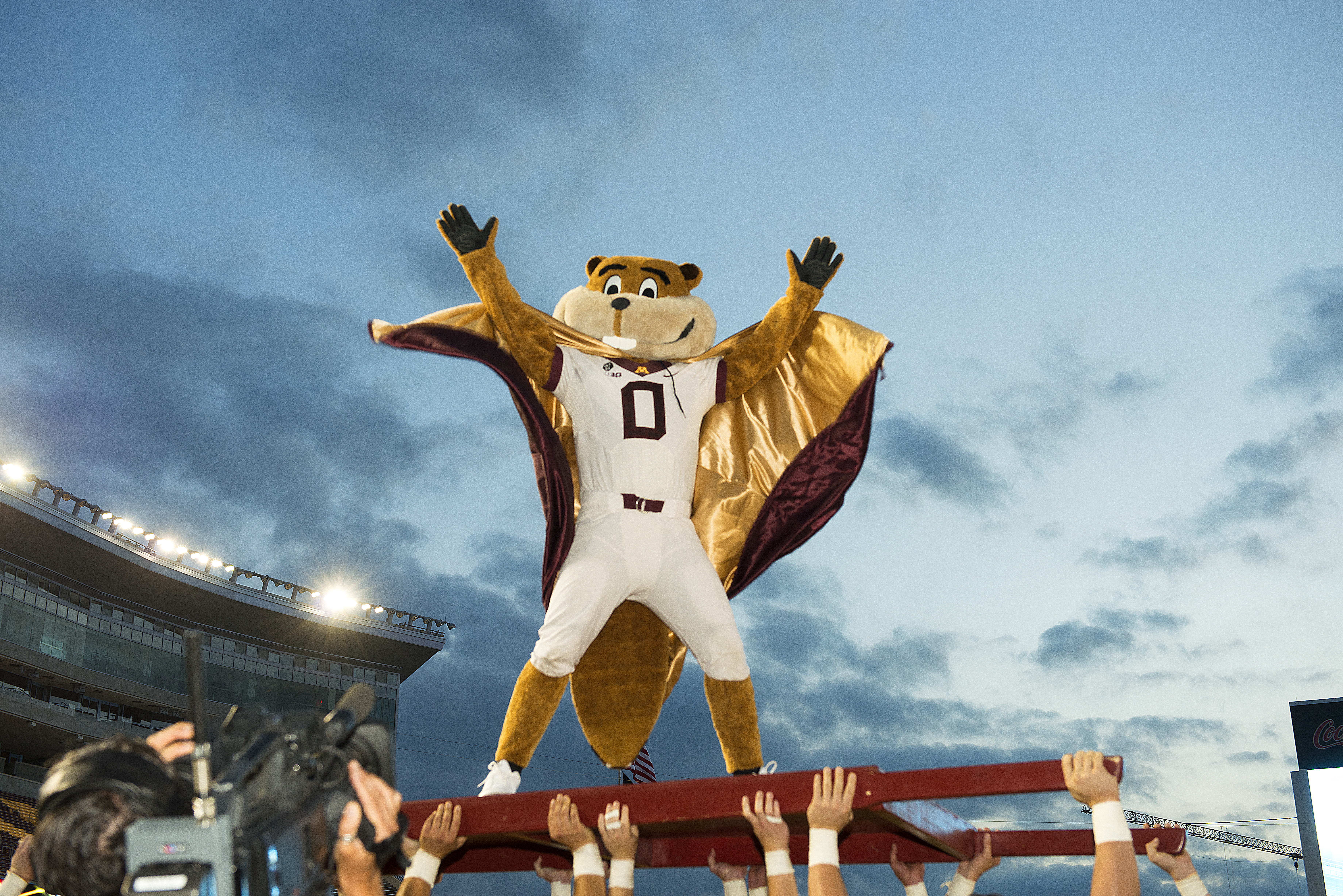 Goldy with a cape at a football game