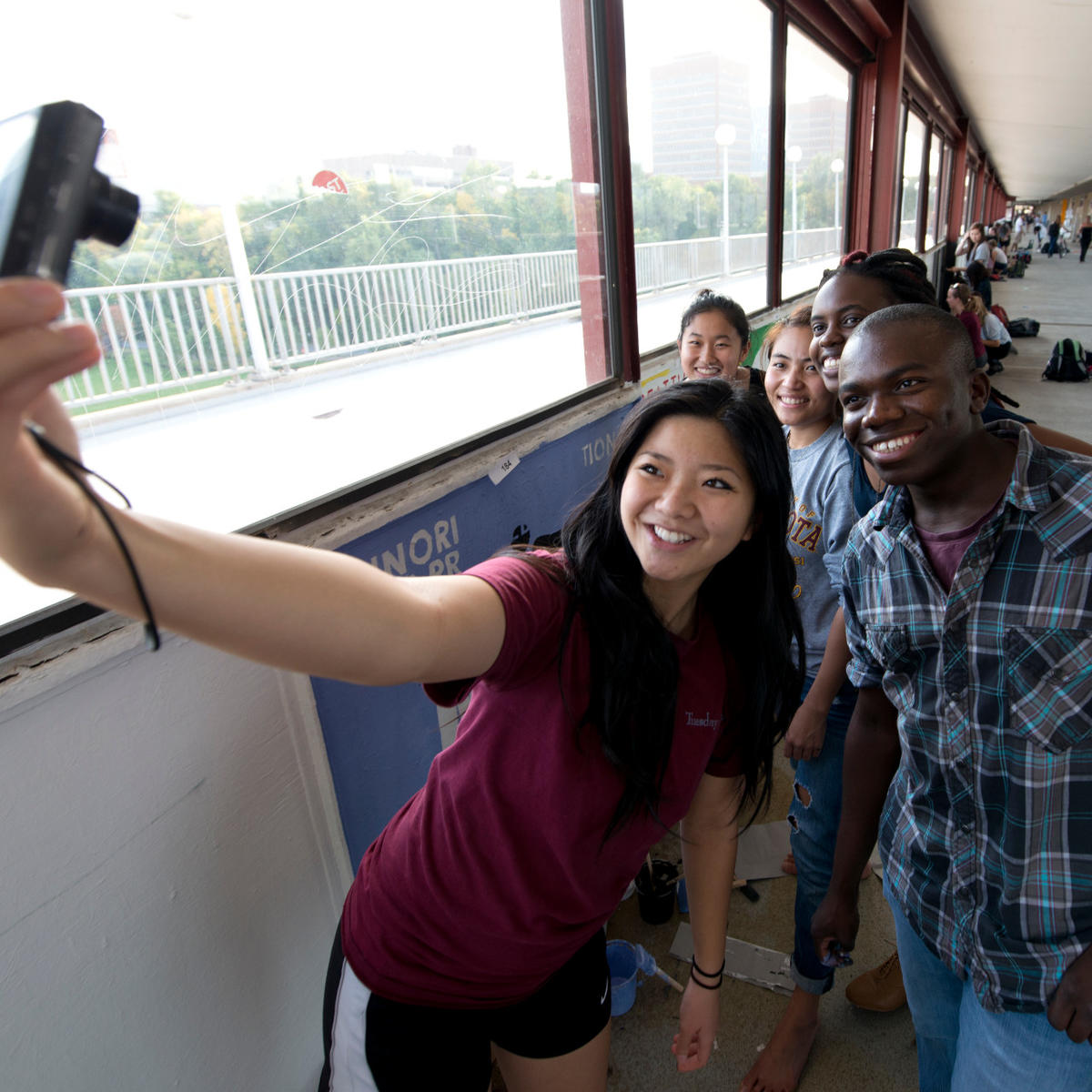 Students take a selfie while painting the bridge