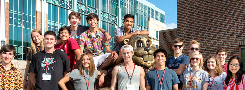 a group of students posing with a Goldy Gopher statue on campus