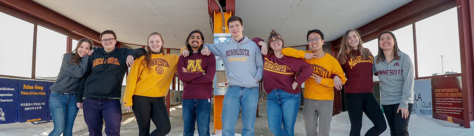 Students stand in front of the Washington Avenue bridge and pose for a photo